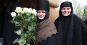 монахиня с букетом цветов