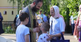 священник благословляет детей