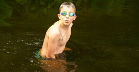 подросток в плавательных очках, река