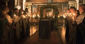 строй священников со свечами
