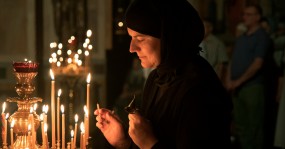 трудница присматривает за свечами