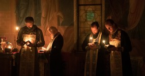 священники в алтаре со свечами