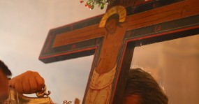 духовник держит крест сосуды