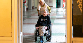 сестра милосердия везет болящего на коляске