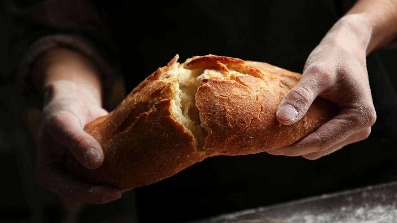 Печеный человек. Булочка в руке. Хлеб в руках. Красивый хлеб.