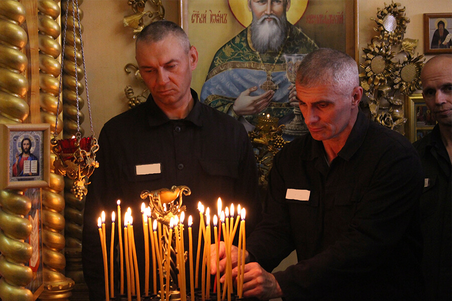 заключенные ставят свечи 