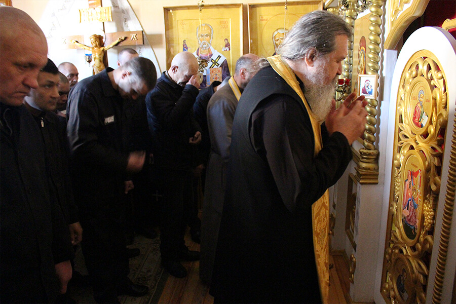 священники и заключенные молятся