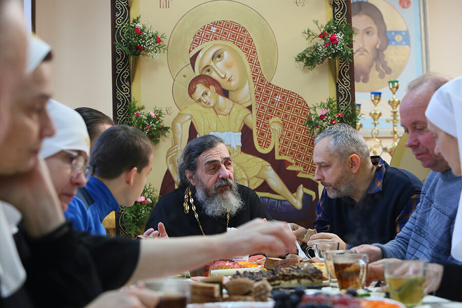 священник с братьями и сестрами за столом