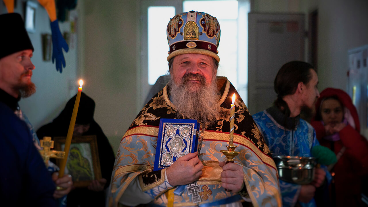 Протоиерей Андрей Лемешонок с Евангелием и свечой