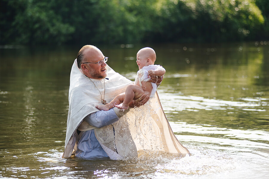 крестят малыша в реке