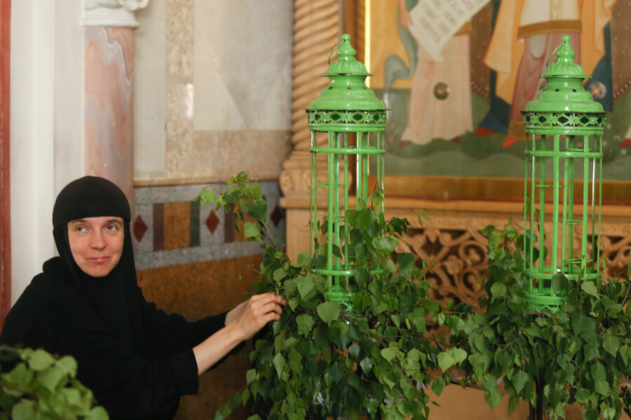 монахиня украшает храм