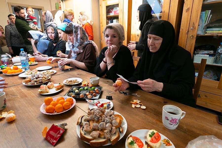 священник и монахиня среди детей