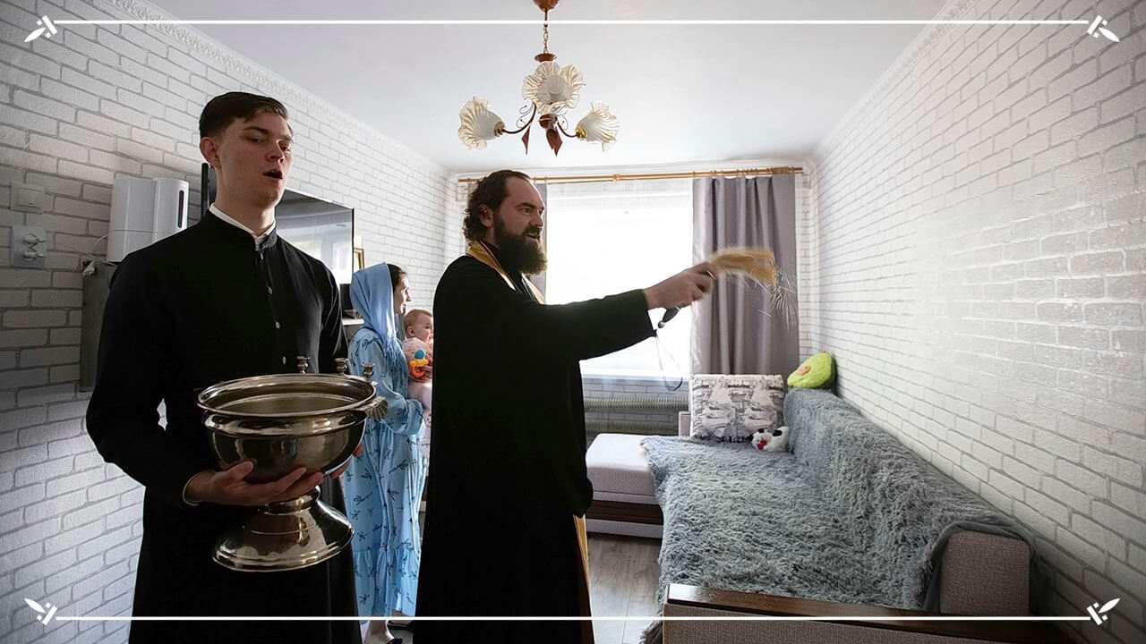 священник освящает дом