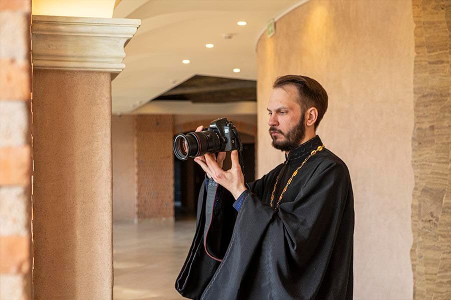 священник с фотоаппаратом