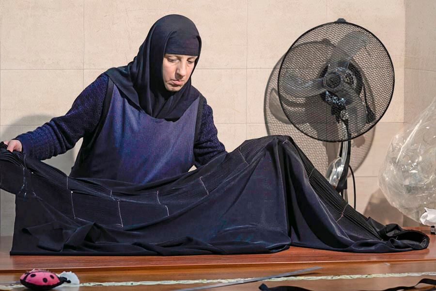 монахиня шьет