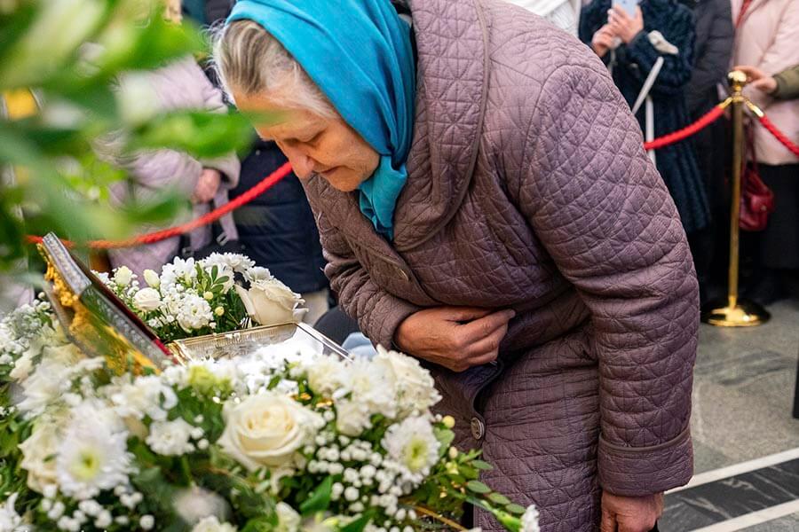 старушка поклоняется святыне