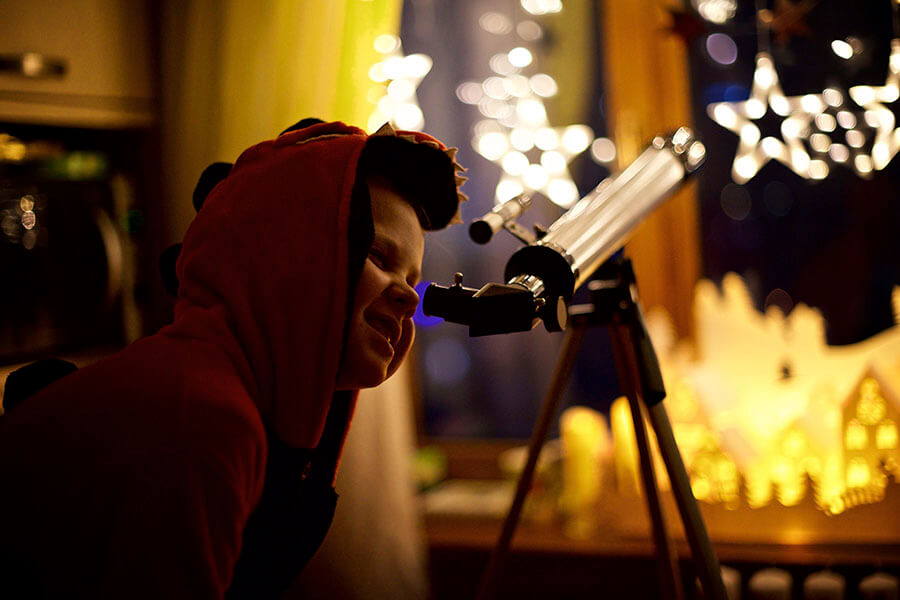 ребенок смотрит в телескоп
